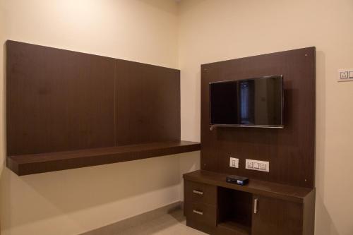 a room with a flat screen tv on a wall at Hotel Blue Bell in Bengaluru