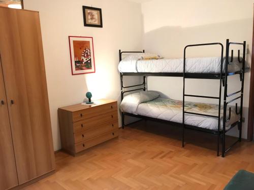 a bedroom with two bunk beds and a wooden floor at Alloggio turistico La Condemine VDA Introd CIR 0001 in Introd