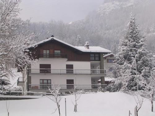 una casa nella neve con alberi innevati di Alloggio turistico La Condemine VDA Introd CIR 0001 a Introd