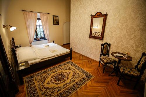 1 dormitorio con cama, mesa y espejo en Kaštieľ Fričovce, en Fričovce
