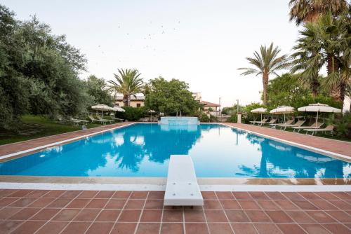 a large swimming pool with a bench in the middle at Agriturismo Il Granaio Hotel & SPA in Modica