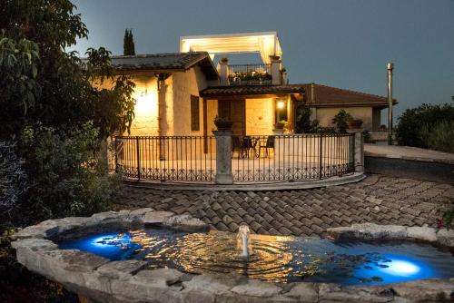 a home with a pond in front of a house at Agriturismo Il Granaio Hotel & SPA in Modica