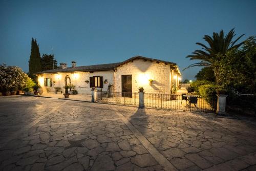 a white house with a fence in front of it at Agriturismo Il Granaio Hotel & SPA in Modica