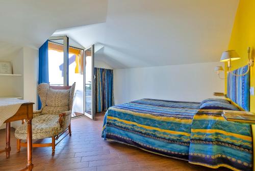 a bedroom with a bed and a desk and a chair at Cà De Rossana Bed&Breakfast in Sanremo