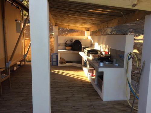 an outdoor kitchen with a stove in a house at Tente Lodge Bord de Mer in Coti-Chiavari