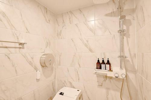 a bathroom with three bottles of wine on a shelf at Ulsan Hotel 109 in Ulsan
