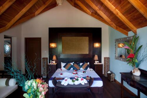 een slaapkamer met een groot bed met bloemen erop bij Le Relax Beach House in La Digue