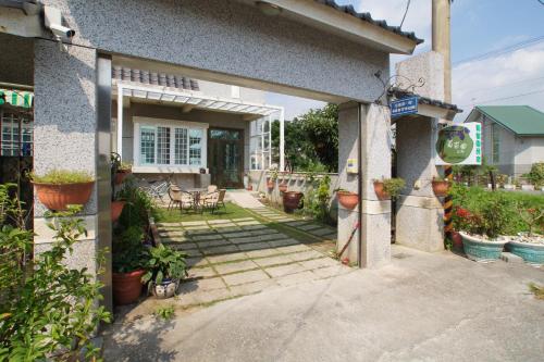 a house with a patio with potted plants on it at Vineyard Guest House in Taitung City