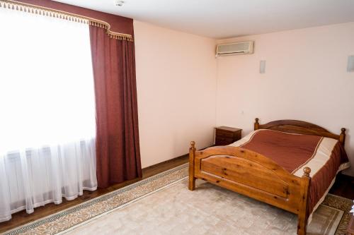 a bedroom with a wooden bed and a window at Belovezhskaya pushcha Hotel №2 in Kamianiuki