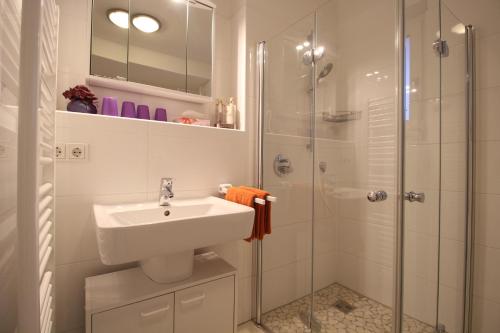 a white bathroom with a sink and a shower at Pearl Royale in Garmisch-Partenkirchen