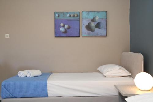 a bed in a room with two pictures on the wall at Blue Sky in Galissas