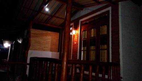 a house with a door and a porch at night at Cozy Homestay Waterfall Road Ella in Ella