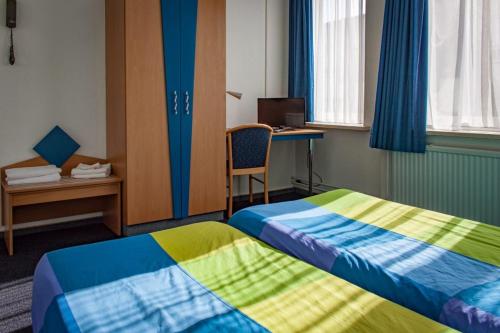 een hotelkamer met 2 bedden en een bureau bij Rumpenerhof in Brunssum