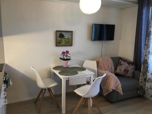sala de estar con mesa, sillas y sofá en Lahti City Home, en Lahti