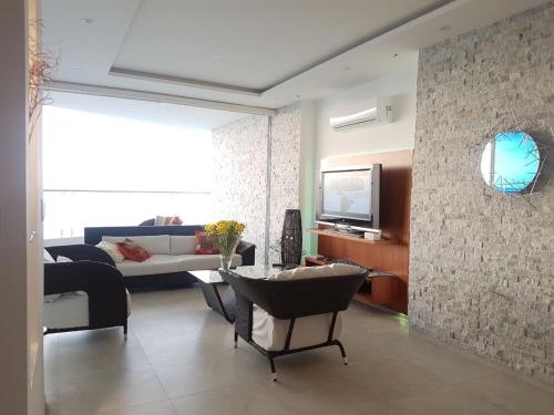 a living room with a couch and a tv at Amplio 140m2 Grand Diamond Tonsupa in Tonsupa