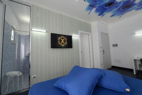 a bedroom with a blue bed and a clock on the wall at X Hotel in Saviano
