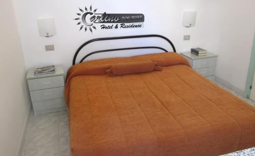 ガリポリにあるAppartamenti Baia Verde Gallipoli di Carlino Touristのベッド1台(オレンジ色の掛け布団付)