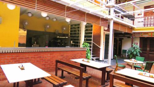 a restaurant with tables and chairs and a brick wall at Mangaldas Ni Haveli II by The House of MG in Ahmedabad