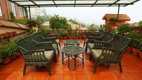 a group of chairs and a table on a patio at Kodai Resort Hotel, Kodaikanal in Kodaikānāl