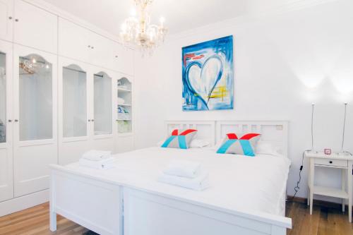 a white bedroom with a white bed and a chandelier at Imperial, 6 in Madrid