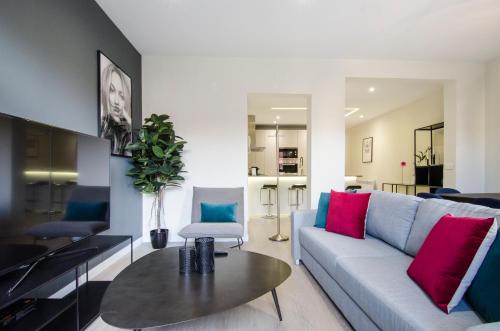 ein Wohnzimmer mit einem Sofa und einem Tisch in der Unterkunft Minty Stay - 3 BD Lavapies in Madrid