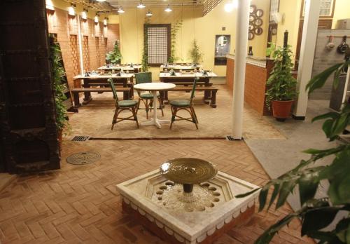 a room with tables and chairs and a fountain at Mangaldas Ni Haveli II by The House of MG in Ahmedabad