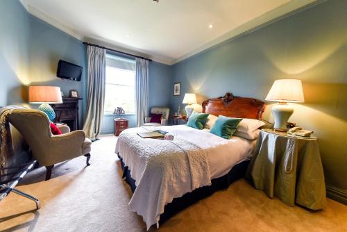 a bedroom with a large bed and a chair at The Traddock in Austwick