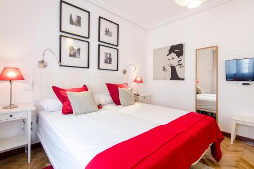 sypialnia z dużym białym łóżkiem z czerwoną pościelą w obiekcie Huertas, 58 w Madrycie