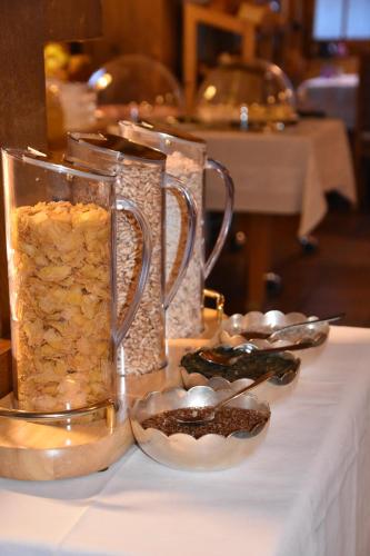 a table with two glass vases with food on it at Hotel Gletschergarten in Grindelwald