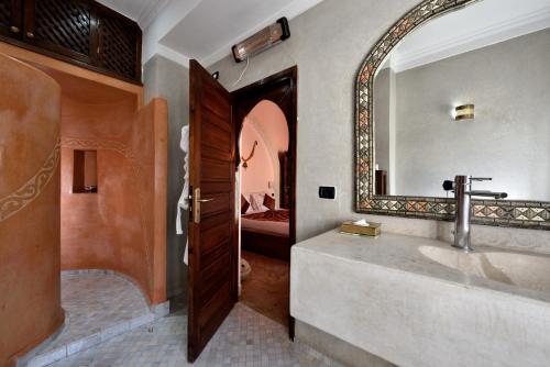 a bathroom with a large mirror and a sink at Riad les Ammonites and Spa in Marrakesh