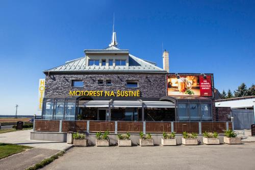 a building with a sign on the front of it at Hotel Na Šustně in Krupá