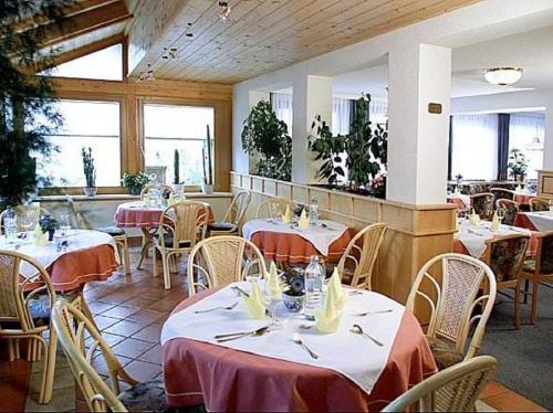 a restaurant with tables and chairs in a room at Familienhotel Steindl in Millstatt