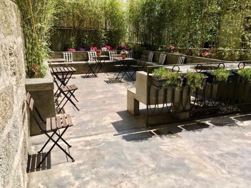 a patio with chairs and tables with flowers and a fence at Porto Vintage Guesthouse in Porto
