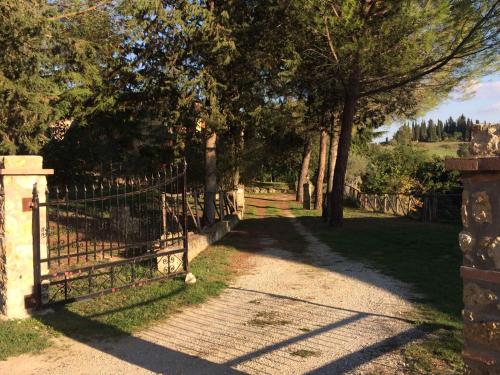 une porte menant à un jardin avec des arbres et une colline dans l'établissement Case Vacanza Podere Risoino, à Poggibonsi