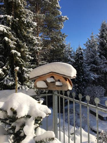 a bird house covered in snow next to a fence at Apart-Elisabeth in Mieming