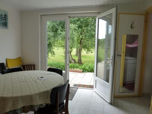 d'une salle à manger avec une table et une porte coulissante en verre. dans l'établissement La maison dans le pré, à Agon-Coutainville