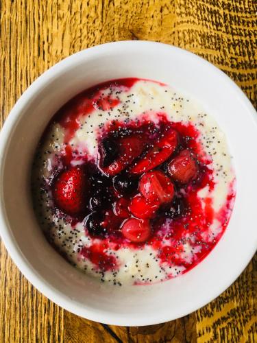 a bowl of yogurt with berries and powdered sugar at The Grosvenor Arms in Shaftesbury