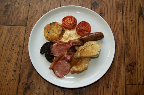 a plate of breakfast food with sausage and eggs at The Grosvenor Arms in Shaftesbury