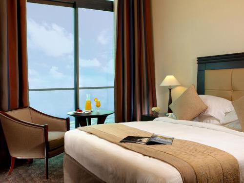 a hotel room with a bed and a large window at Raouche Arjaan by Rotana in Beirut