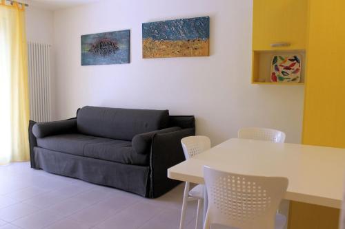 - un salon avec un canapé et une table dans l'établissement Appartamenti Grado, à Grado