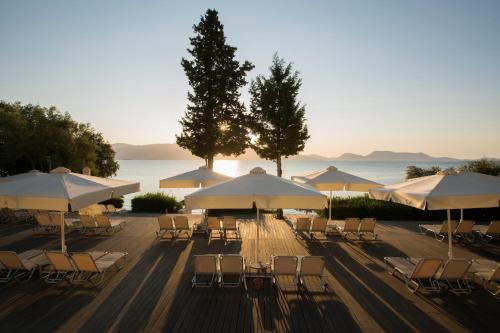 a group of tables and chairs with umbrellas at Porto Galini Seaside Resort & Spa in Nikiana