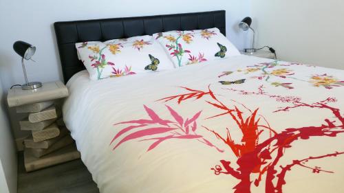 - une chambre avec un lit orné d'oiseaux et de fleurs dans l'établissement Magnifique vue Mer et Forêt, à Cabourg