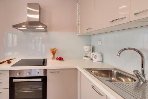 a white kitchen with a sink and a stove at Croatica Suites Brodarica in Brodarica