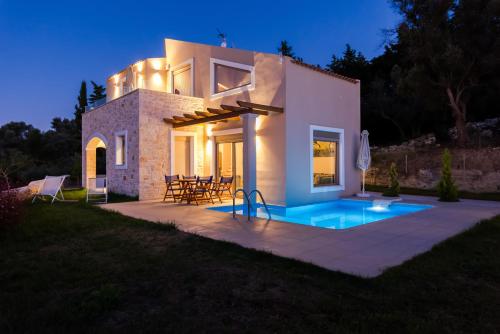 a villa with a swimming pool at night at Mon Emvasia Margarites Villas in Margarítai