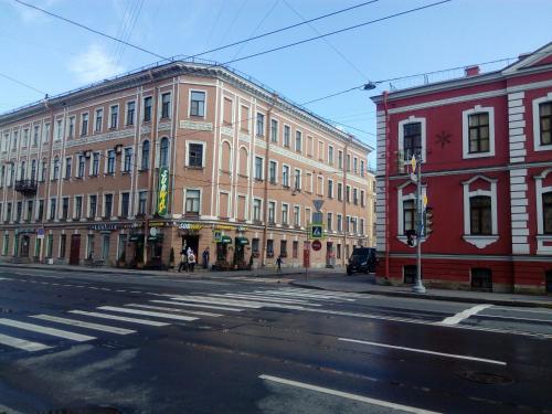 an empty city street with buildings and a crosswalk at Marseille Hostel in Saint Petersburg