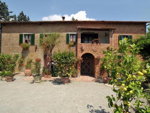 una casa de ladrillo con plantas delante de ella en Belvilla by OYO Casale le Capanne, en Cortona