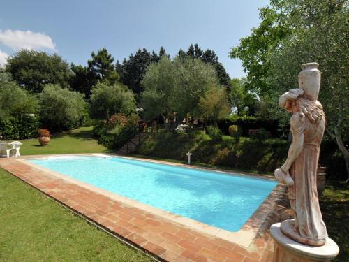 una estatua de una mujer parada junto a una piscina en Belvilla by OYO Casale le Capanne, en Cortona