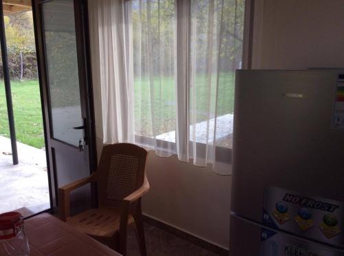 a kitchen with a chair next to a window at Taripiri in Ambrolauri