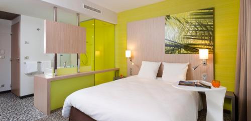 um quarto de hotel com uma cama grande e uma mesa em ibis Styles Troyes Centre em Troyes