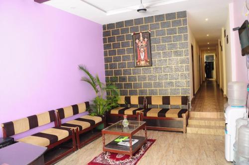 salon z kanapami i ścianą wyłożoną kafelkami w obiekcie SGS Residency w mieście Tirupati